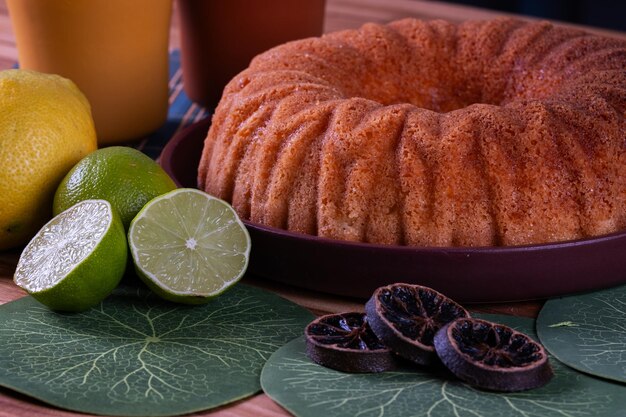 Foto delicioso bolo de limão na mesa com copos e limões ao lado