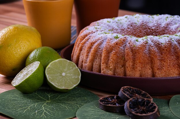 Foto delicioso bolo de limão na mesa com copos e limões ao lado