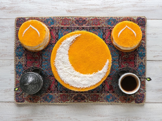 Delicioso bolo dourado caseiro com lua crescente, servido com café preto. Parede do Ramadã