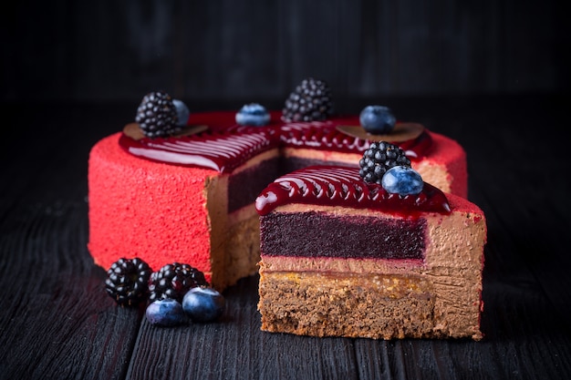 Delicioso bolo rosa com frutas na mesa de madeira