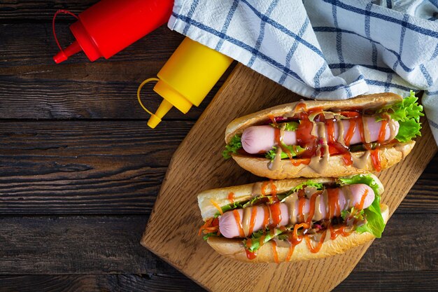 Delicioso cachorro-quente com ketchup e mostarda em fundo de madeira. comida de rua