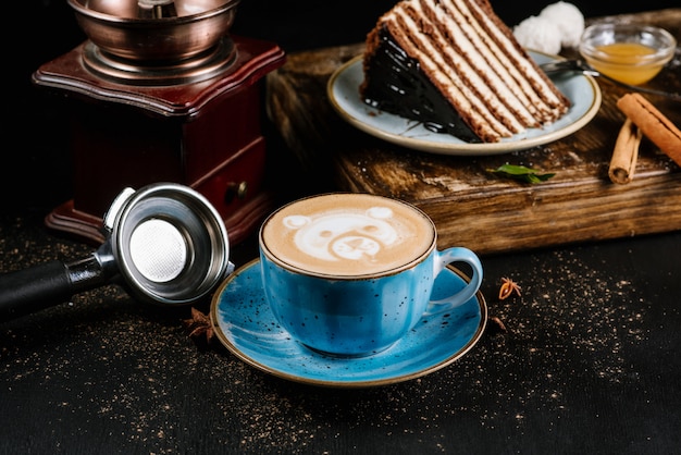 Delicioso café capuchino fresco de la mañana en una taza de cerámica azul sobre negro