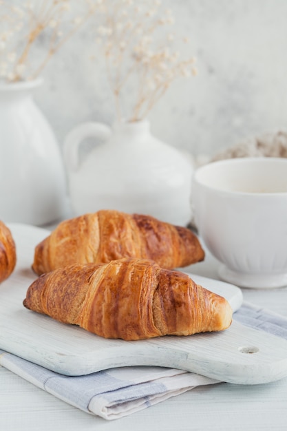 Delicioso café da manhã com croissants frescos e café em uma madeira branca. Bolos deliciosos