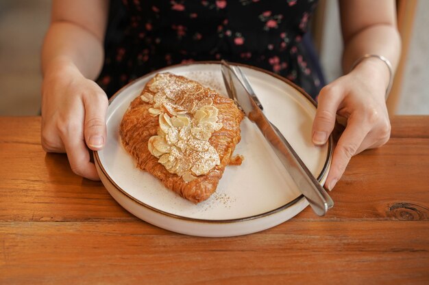 Delicioso café da manhã com croissants frescos e café servido com manteiga na mesa de madeira.