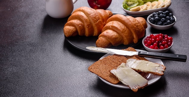 Delicioso café da manhã com croissants frescos e frutos maduros em uma linda mesa de madeira