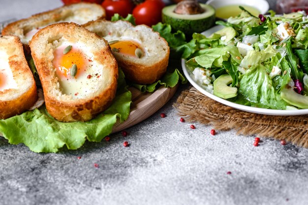 Delicioso café da manhã com grunhidos, ovos, abacate e tomate cereja. Refeição matinal agradável com sanduíches frescos