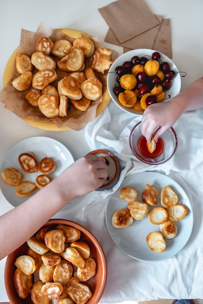 Delicioso café da manhã com mini panquecas, cerejas, geléia de damascos