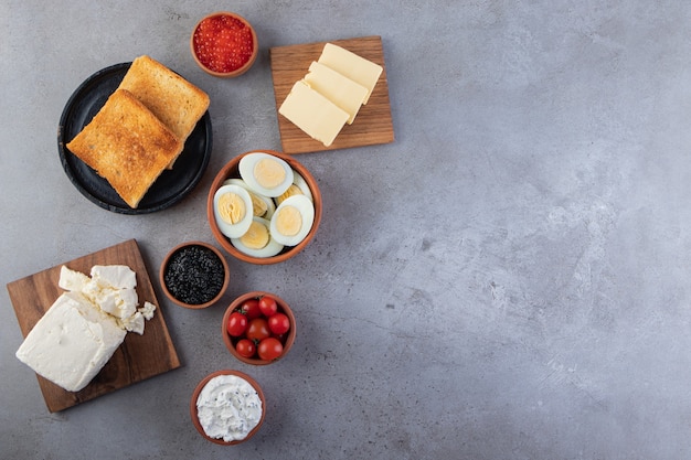 Delicioso café da manhã com ovos, torradas e queijo na mesa de pedra.