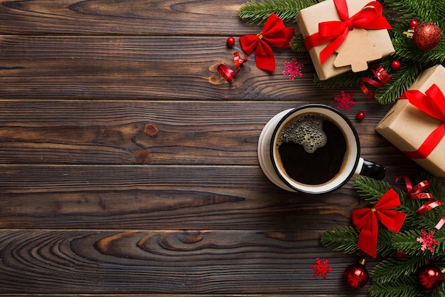 Delicioso café da manhã festivo fresco em uma xícara de cerâmica com enfeites de presentes embrulhados e brinquedos de natal Xícara de café e brinquedos de ano novo