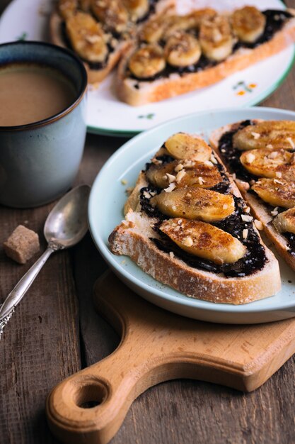 Delicioso café da manhã francês - torrada com chocolate e banana frita em fundo de madeira