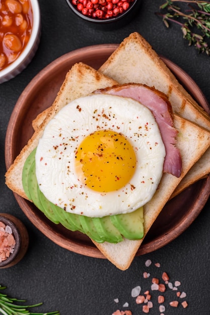 Delicioso café da manhã inglês nutritivo com ovos fritos, tomate e abacate