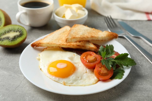 Delicioso café da manhã ou almoço com ovos fritos na superfície cinza, close-up