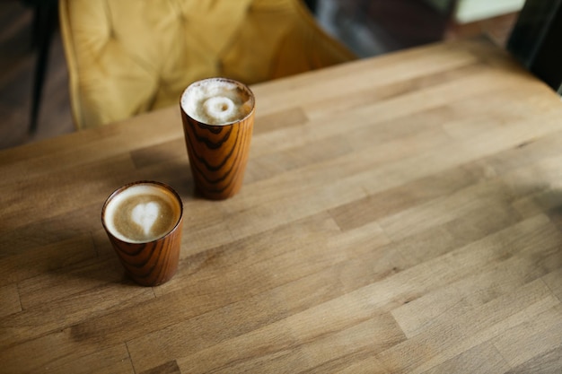 Delicioso café e cappuccino na mesa em um café Bom dia Mesa de madeira Os óculos ficam em uma mesa de madeira