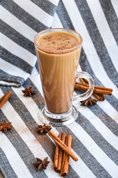 Delicioso café gelado e bebida derretida com leite, paus de canela e estrelas de anis, café com leite ou machiato