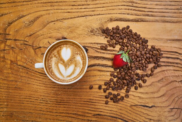 Delicioso café con leche y fresa roja.