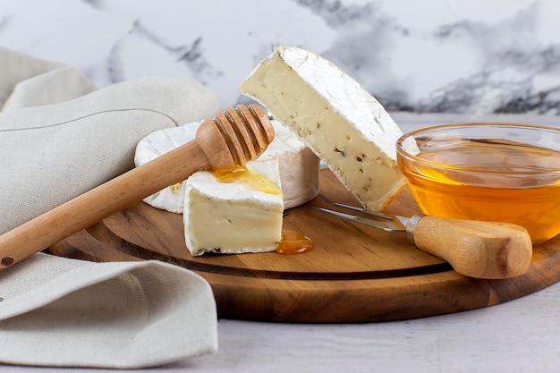 Delicioso camembert con miel en el espacio de copia de tablero de madera