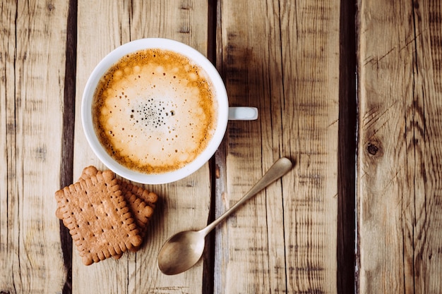 Delicioso cappuccino quente na mesa de madeira