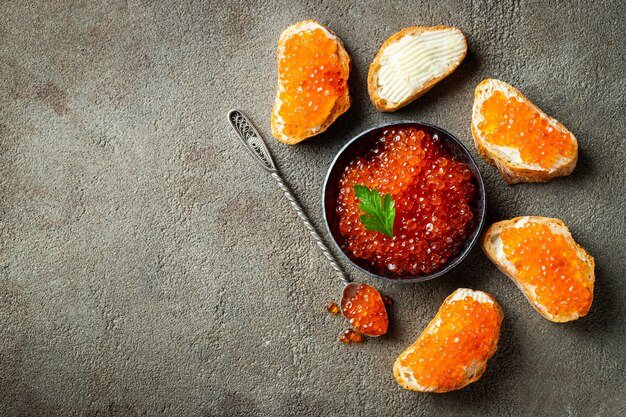 Delicioso caviar rojo en un tazón negro.