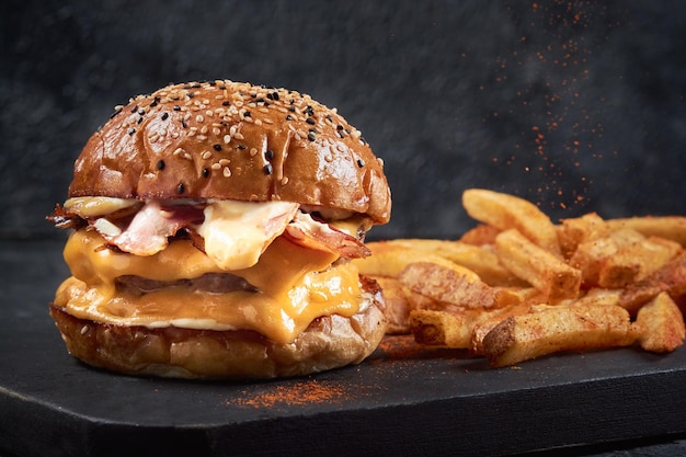 Delicioso cheeseburger duplo e batata frita com pimenta vermelha na lousa