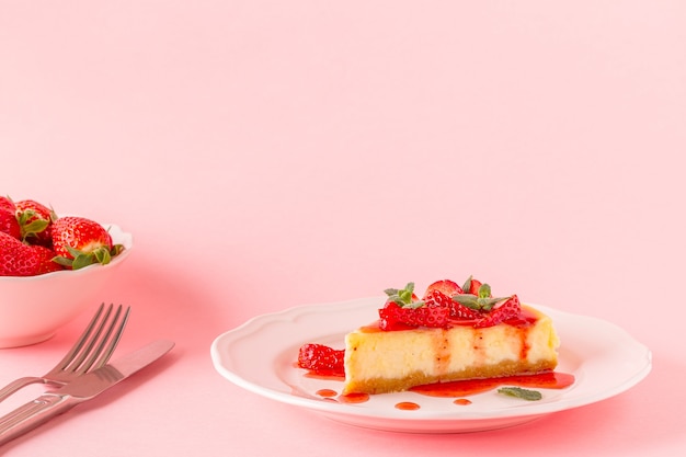 Delicioso cheesecake caseiro com morangos em rosa.