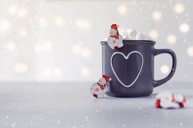 Delicioso chocolate caliente con malvaviscos y pequeños snowmans sobre fondo de piedra gris