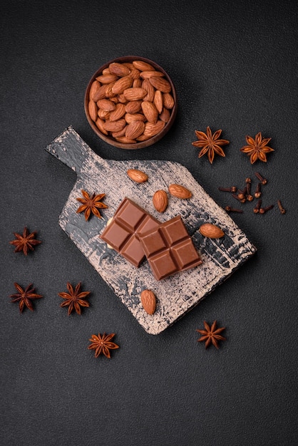 Foto delicioso chocolate con leche dulce roto en cubos sobre una tabla para cortar madera