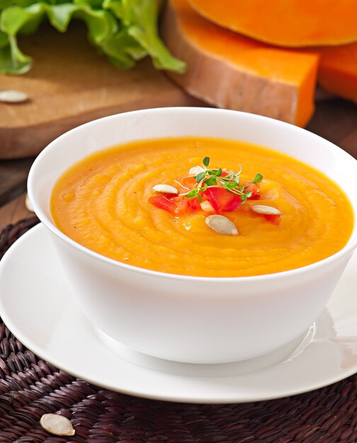 Delicioso creme de sopa de abóbora em uma tigela na mesa de madeira