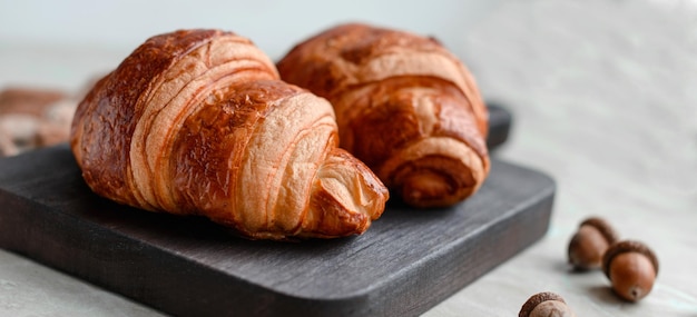 Delicioso croissant crocante com chocolate com uma xícara de café revigorante em um fundo claro de concreto Delicioso café da manhã nutritivo