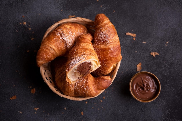 Delicioso croissant dulce con chocolate sobre fondo oscuro