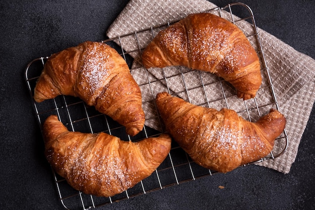 Delicioso croissant recién horneado sobre fondo oscuro