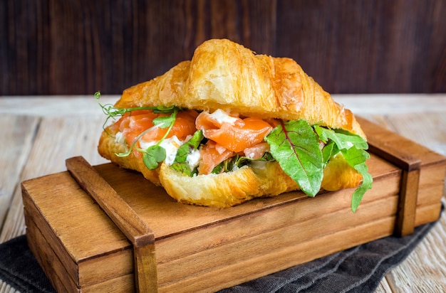 Delicioso croissant con salmón, requesón y hierbas.