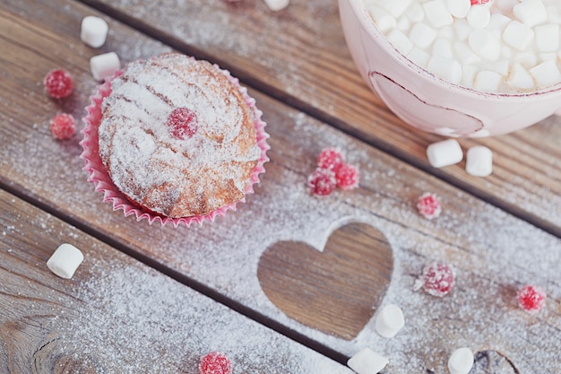 Delicioso cupcake con bayas y una taza de café.