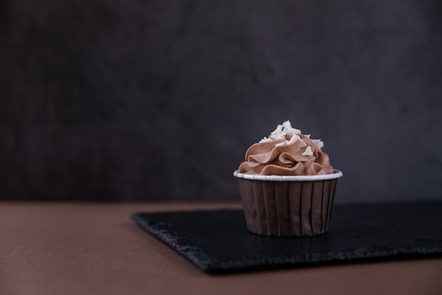 Delicioso cupcake de chocolate con crema y picado de chocolate blanco