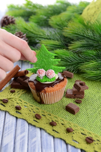 Delicioso cupcake con crema de mantequilla, sobre fondo de madera de color