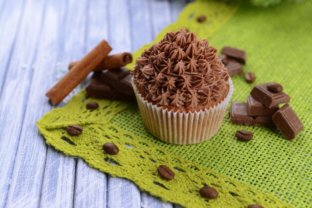 Delicioso cupcake con crema de mantequilla, sobre fondo de madera de color