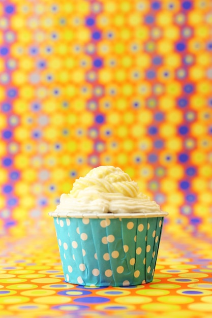 Delicioso cupcake de cumpleaños sobre fondo brillante