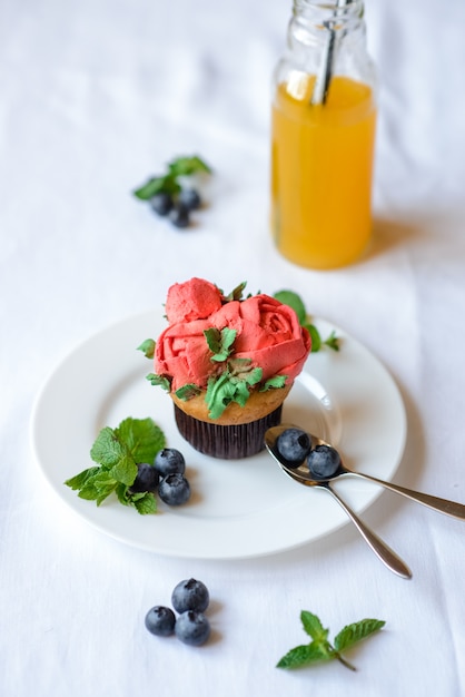 Delicioso cupcake en un plato blanco sobre un fondo blanco.