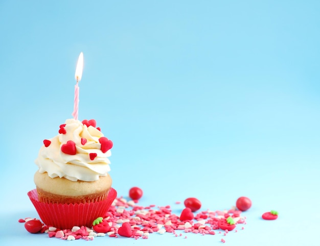 Delicioso cupcake con vela sobre fondo de color