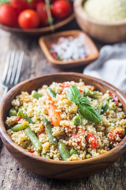 Delicioso cuscuz vegetariano caseiro com tomate, cenoura, feijão verde, pimentão e manjericão fresco