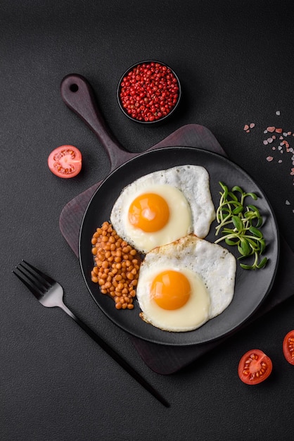 Delicioso desayuno abundante que consta de dos huevos fritos lentejas enlatadas y microvegetales