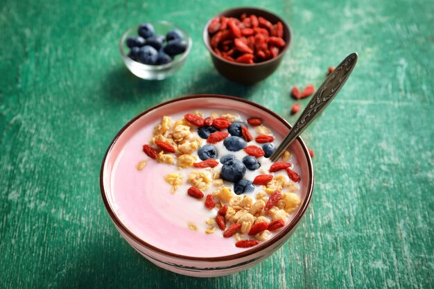 Delicioso desayuno con bayas de goji en un tazón en la mesa