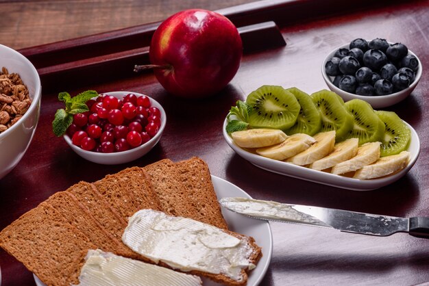 Delicioso desayuno con cruasanes recién hechos y bayas maduras en una hermosa mesa de madera