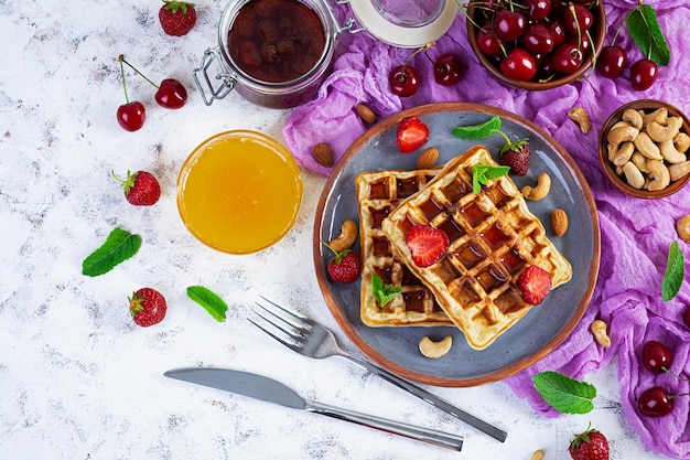 Delicioso desayuno con gofres belgas Gofres con mermelada de fresa y bayas