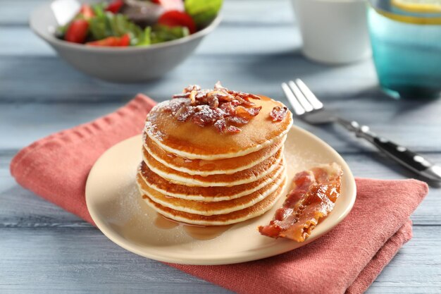 Delicioso desayuno con panqueques y tocino en la mesa