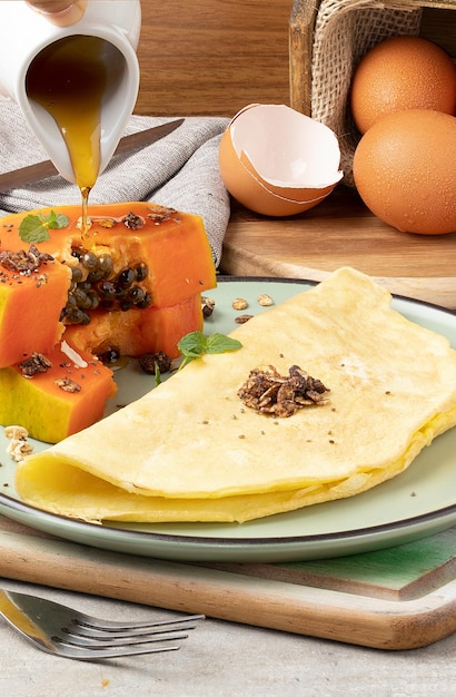 Delicioso desayuno con papaya y crepioca servido con granola, chía y miel.