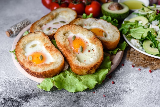 Delicioso desayuno con roncos, huevos, aguacate y tomates cherry. Agradable comida de la mañana con sándwiches frescos