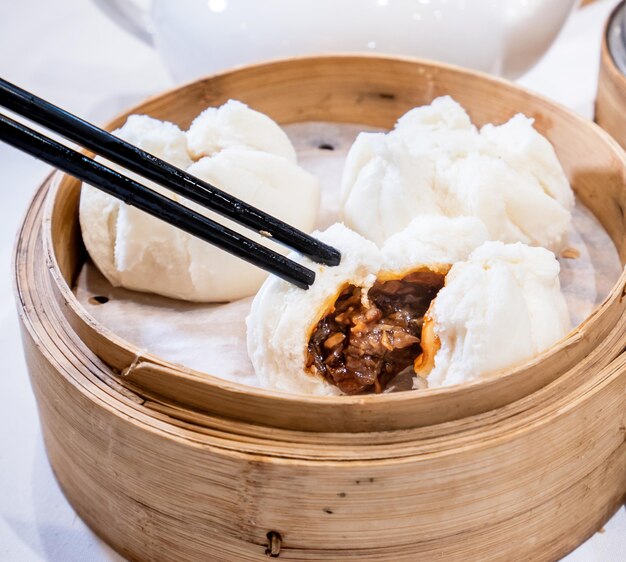 Foto delicioso dim sum comida cantonesa famosa na ásia fresco e quente cha siu bao churrasco de porco em vapor de bambu em hong kong restaurante yumcha de perto