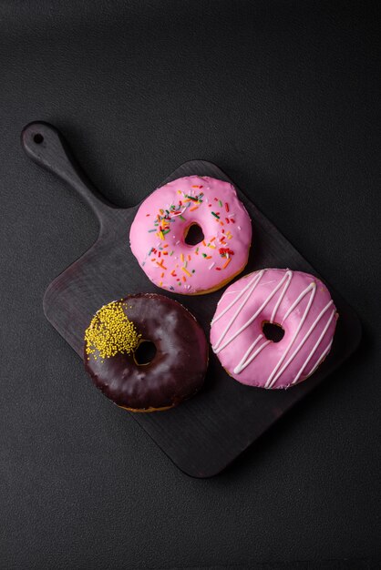 Delicioso donut com recheio de creme e nozes em um fundo escuro de concreto