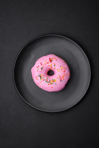 Delicioso donut con relleno de crema y nueces sobre un fondo de hormigón oscuro