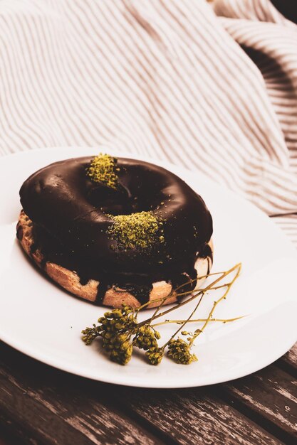 Delicioso donut con salsa de chocolate y trocitos de pistacho